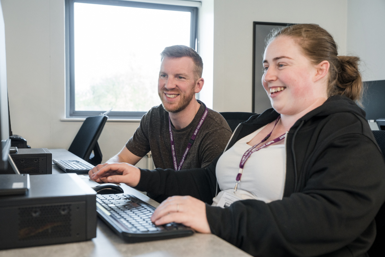 two adult learners working in a computer room