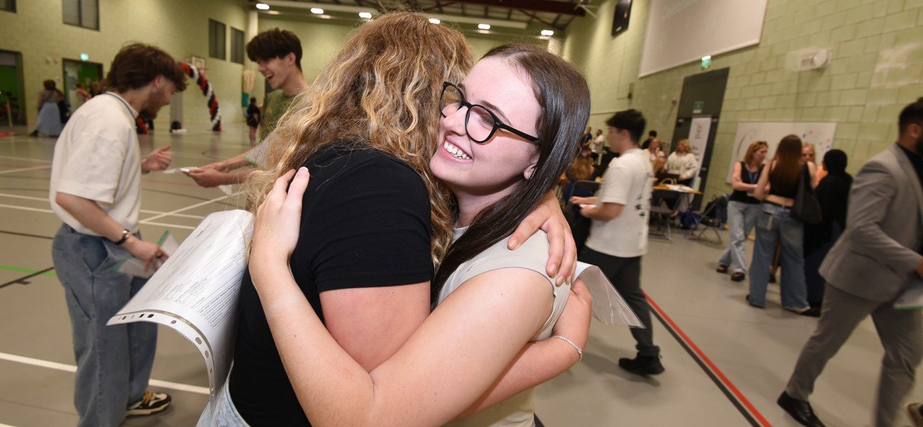 two students hugging after finding out exam results