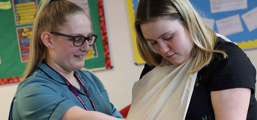 Health and Social Care student demonstrating slinging an arm