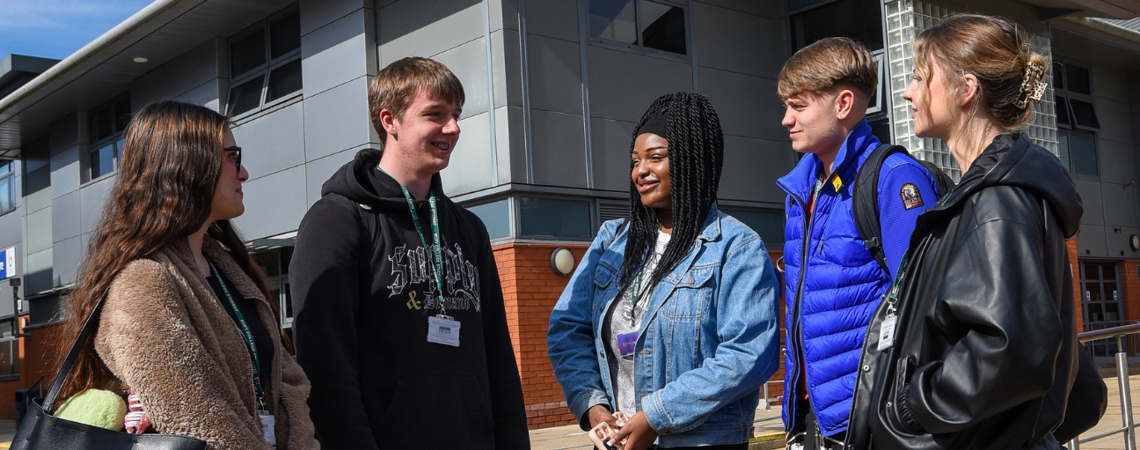 a group of students stood socialising