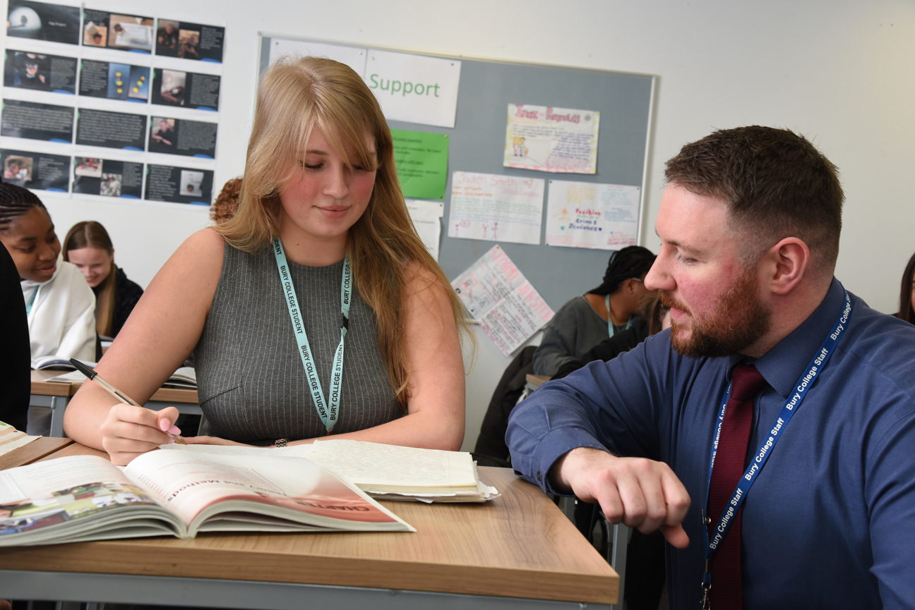 tutor sat helping a student in a classroom