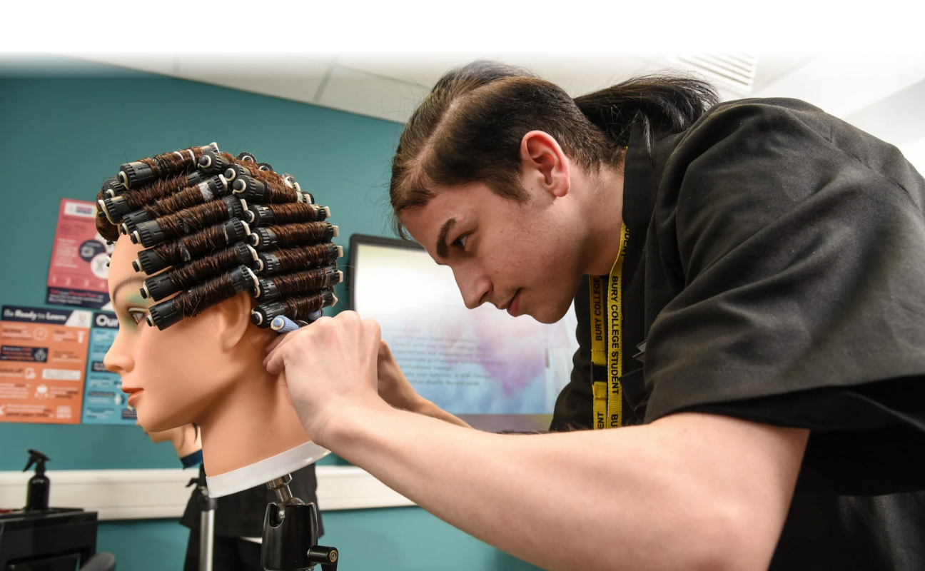 Hairdressing student putting curlers on dolls head