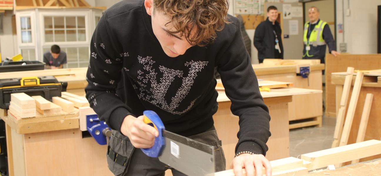 carpentry and joinery student using a saw