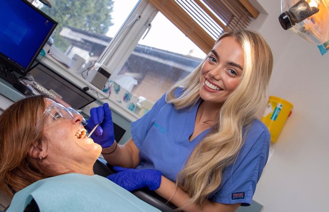 Dental apprentice examining teeth