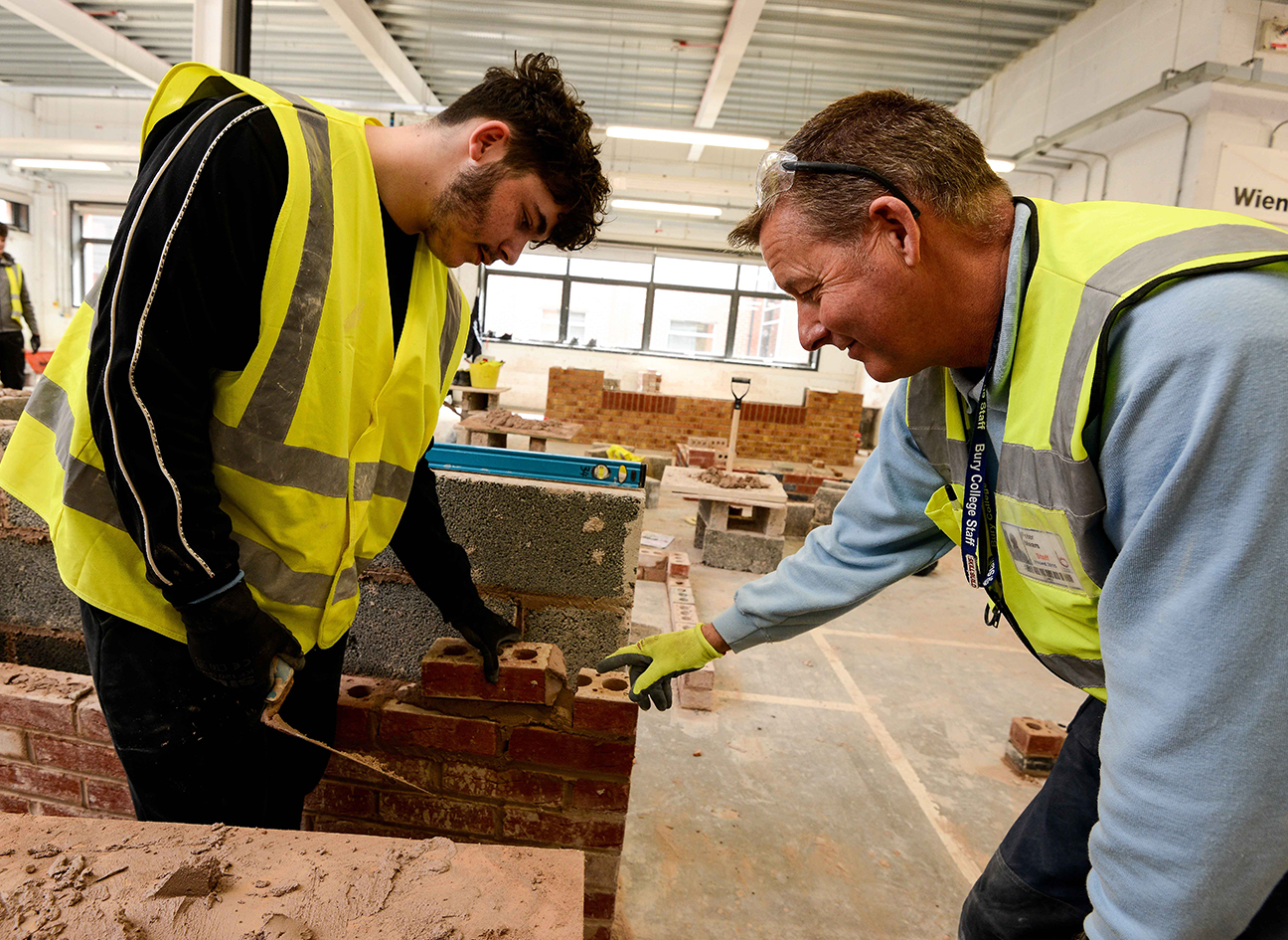 Bricklaying tutor and student laying bricks