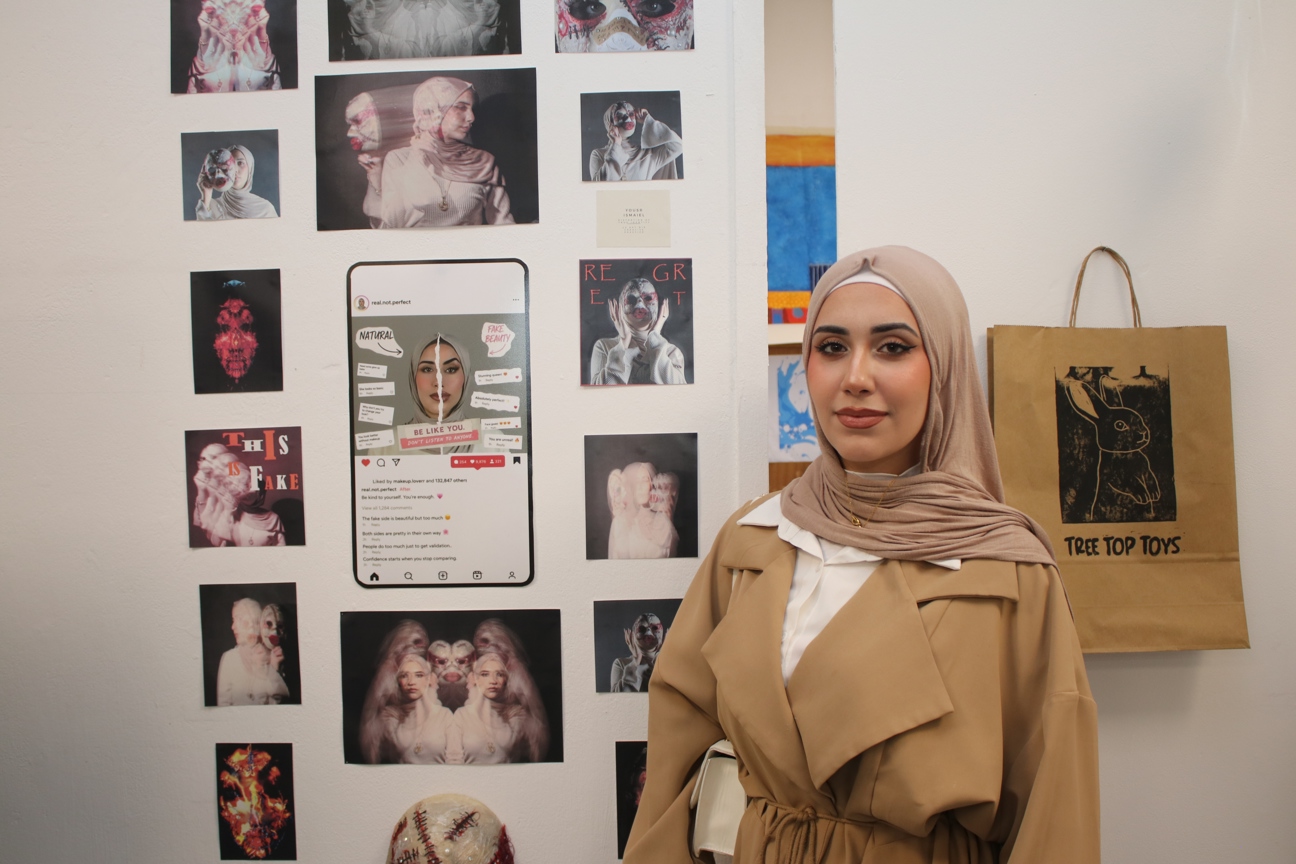 an art student stood in front of their art work