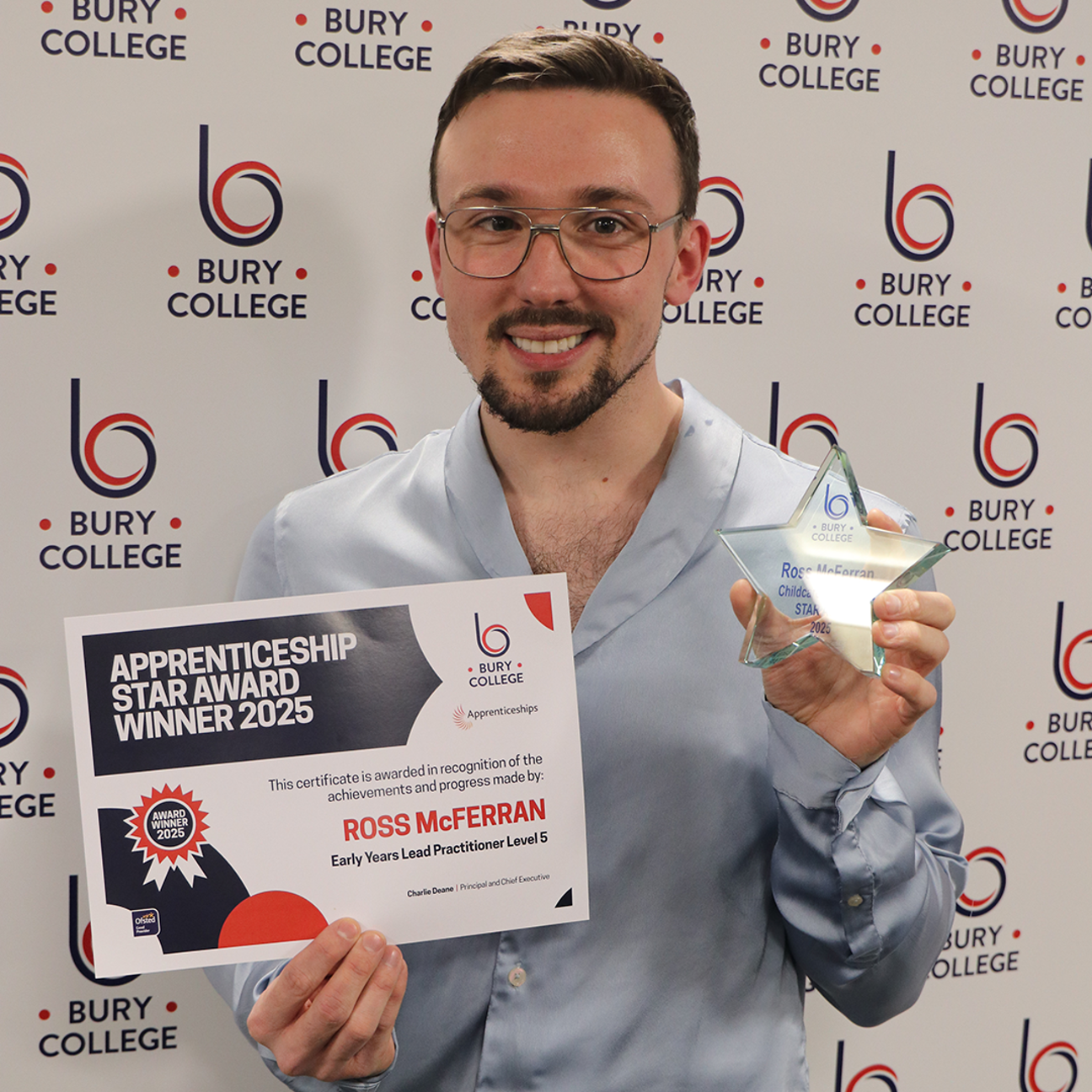 student holding glass trophy and certificate