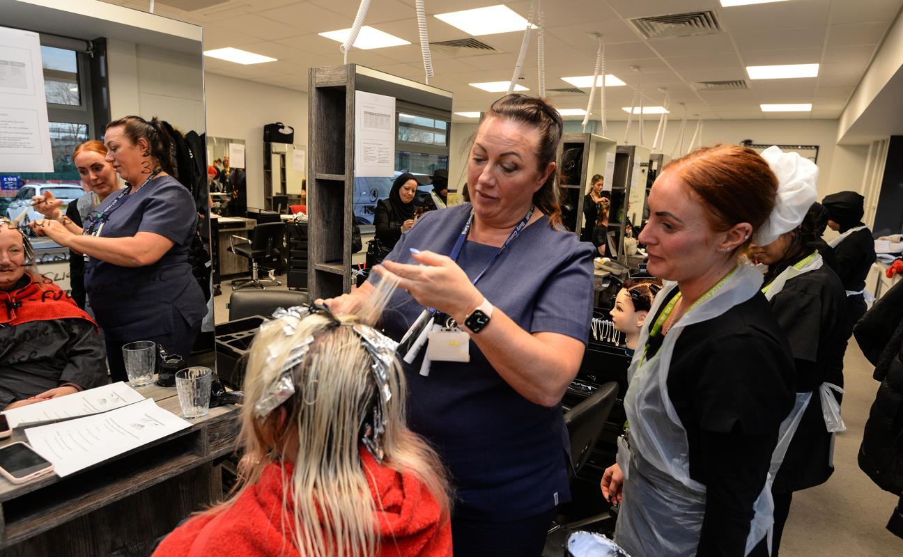 Teacher and hairdressing student using hair foils 