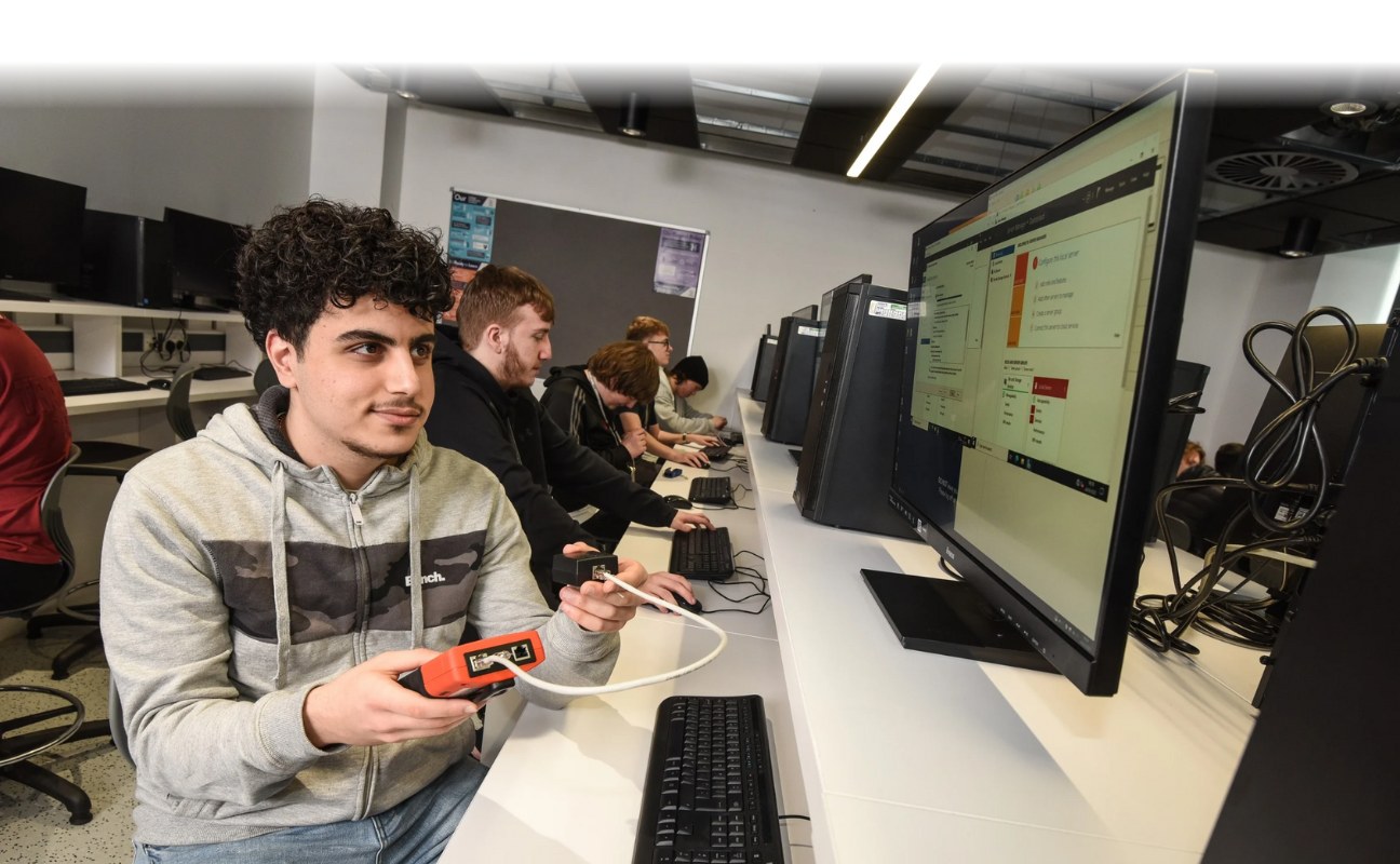 students sat in a classroom working on their computers