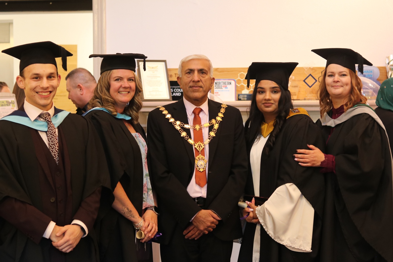 graduates and staff of Bury College stood with the local mayor