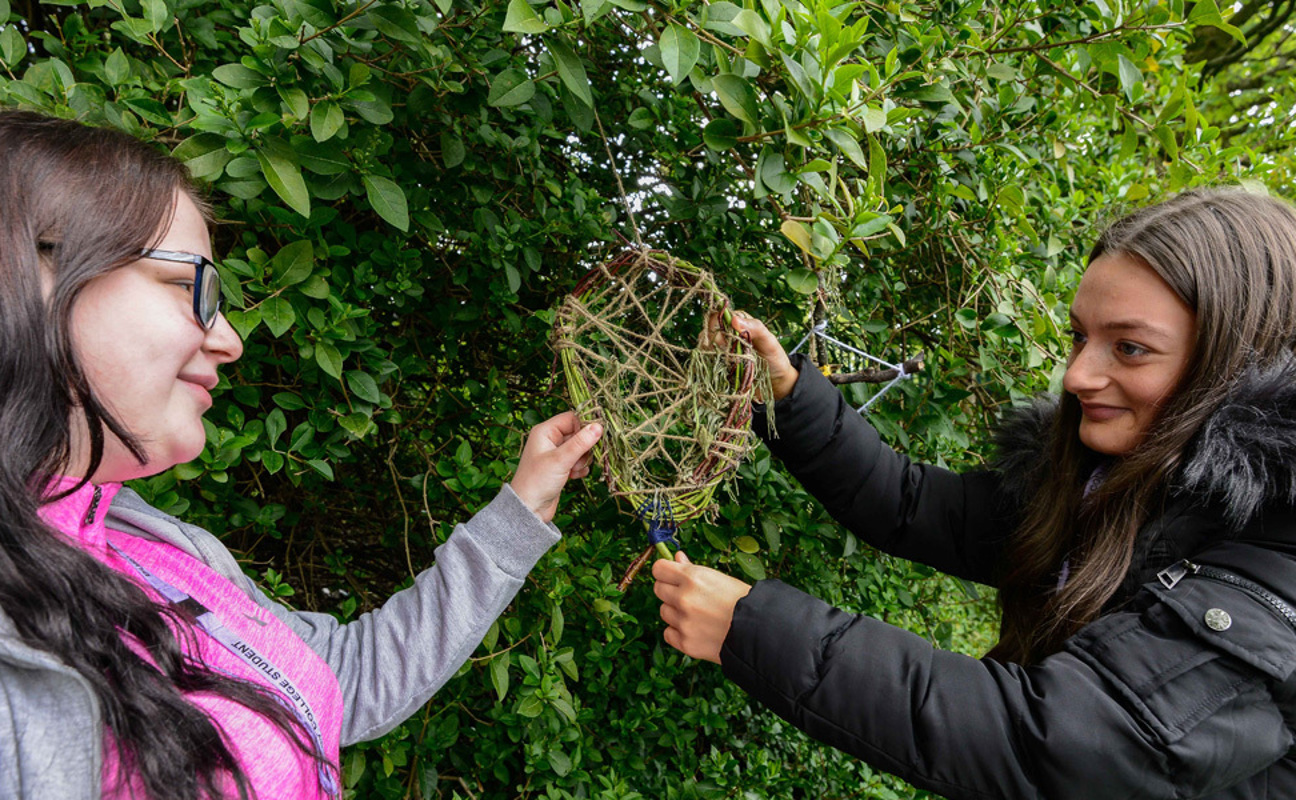 Two students working on forest school activities outdoors