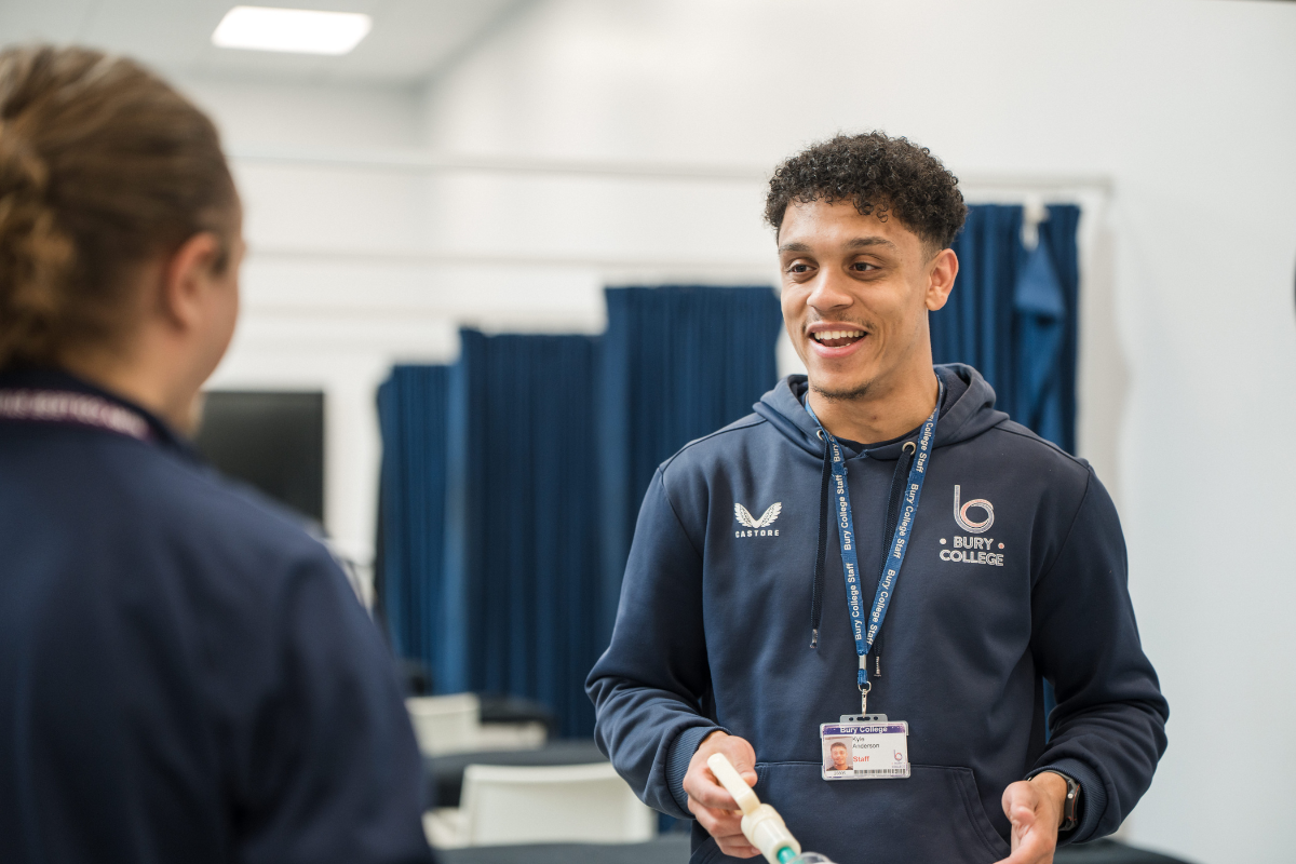 staff member supporting a student in sport class