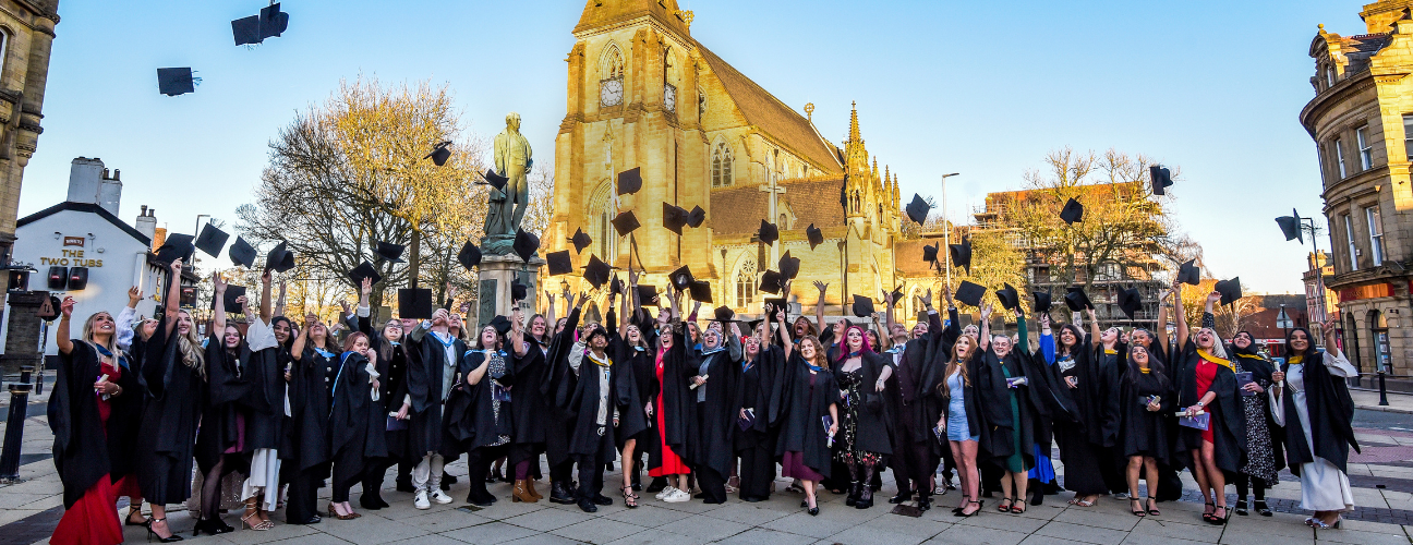 graduates throwing their caps into the air in celebration