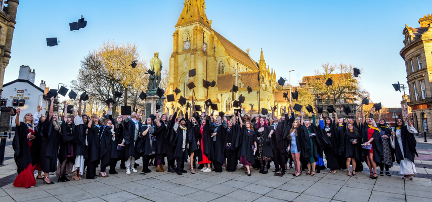 graduates throwing their caps into the air in celebration