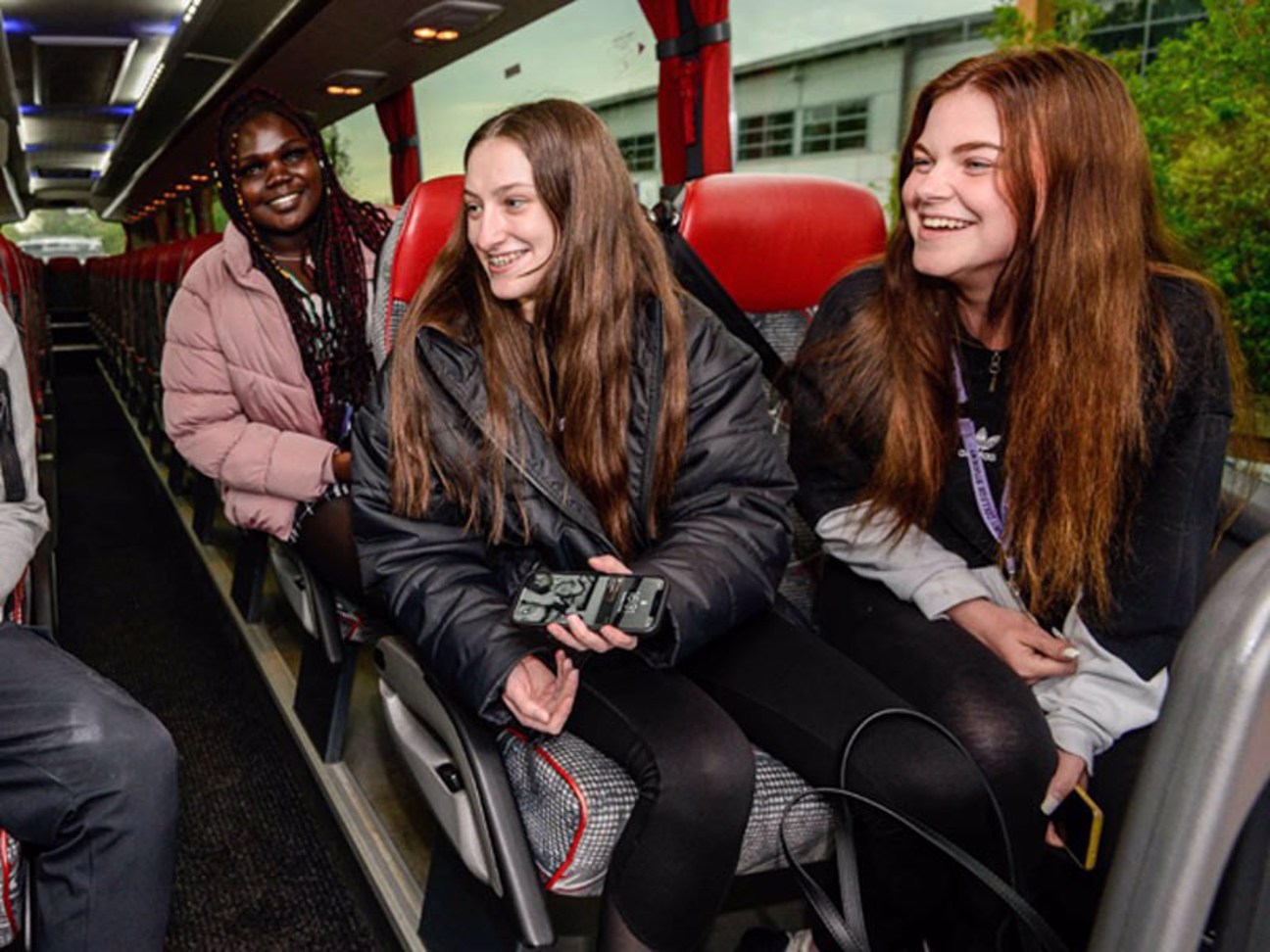 Students smiling on a coach