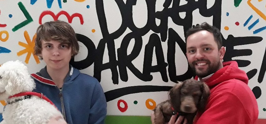 A Foundation Studies student holding a dog with the Managing Director of Stay N Play Doggy Day Care Bury