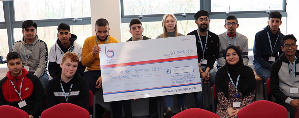 Bury College Business students holding a fundraising cheque