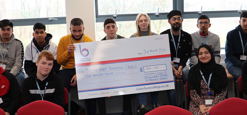 Bury College Business students holding a fundraising cheque