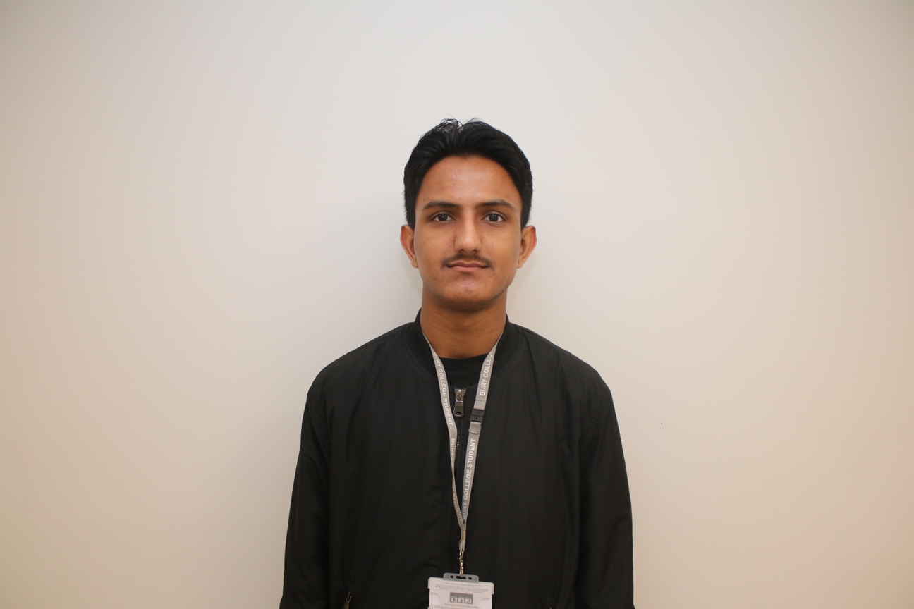 computing student stood in front of a white wall