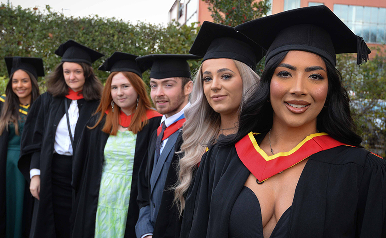 Graduates in a line smiling