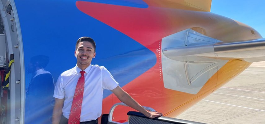 Ketan standing besides an airplane