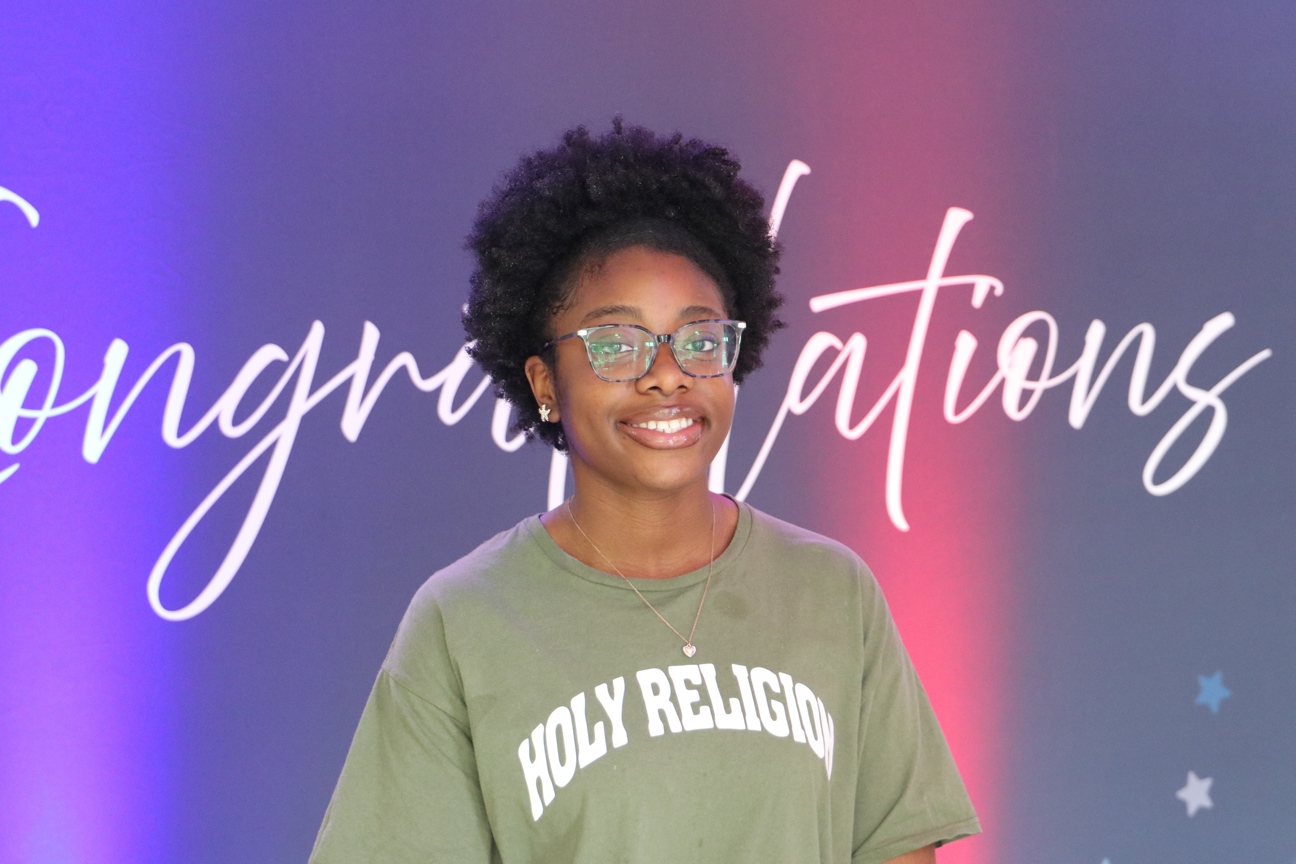 student stood in front of congratulations sign