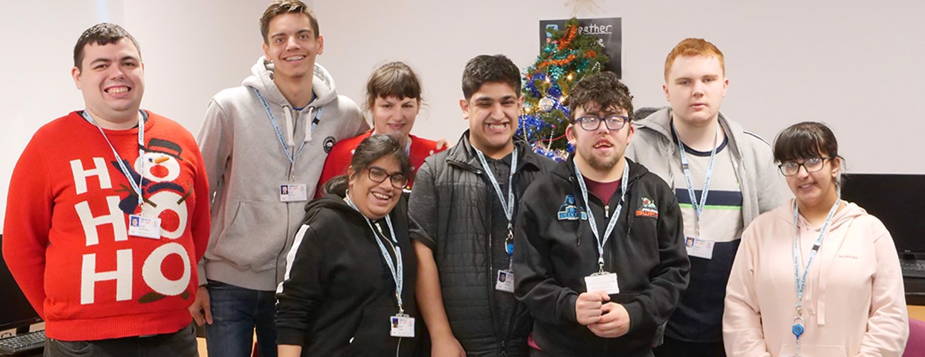A group of students stood in front of a Christmas tree