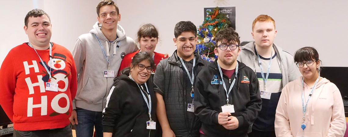A group of students stood in front of a Christmas tree