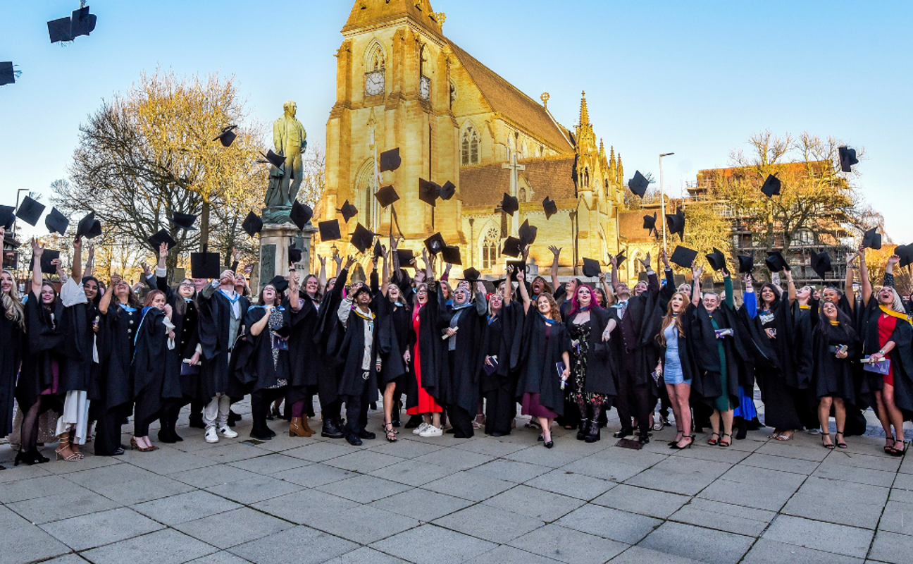 students throwing their caps into the air on graduation day