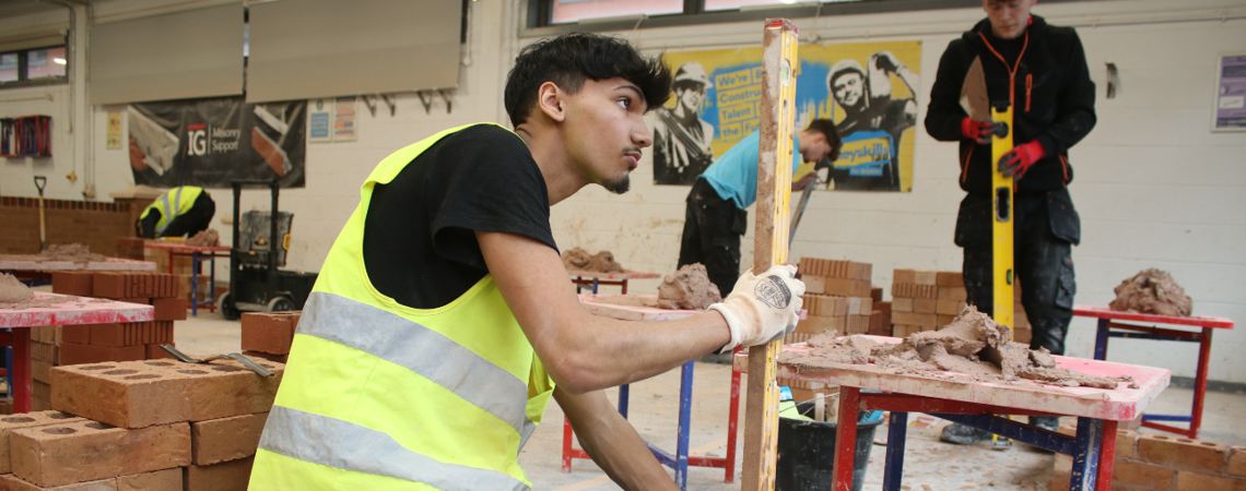 bricklaying student using a spirit level