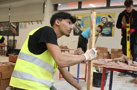 bricklaying student using a spirit level