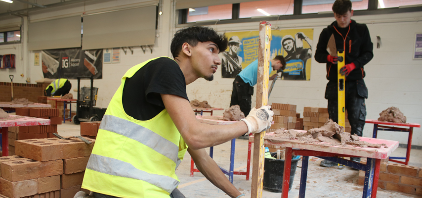 bricklaying student using a spirit level