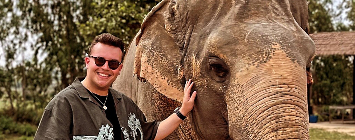 Nathan standing next to an elephant