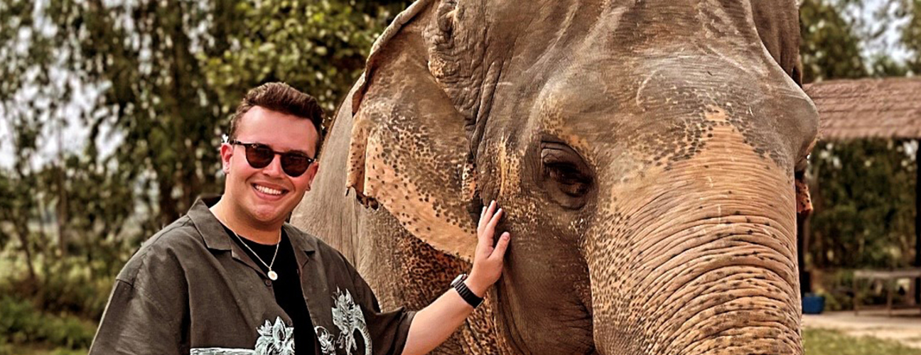 Nathan standing next to an elephant