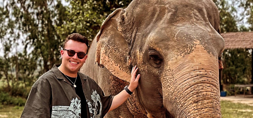 Nathan standing next to an elephant