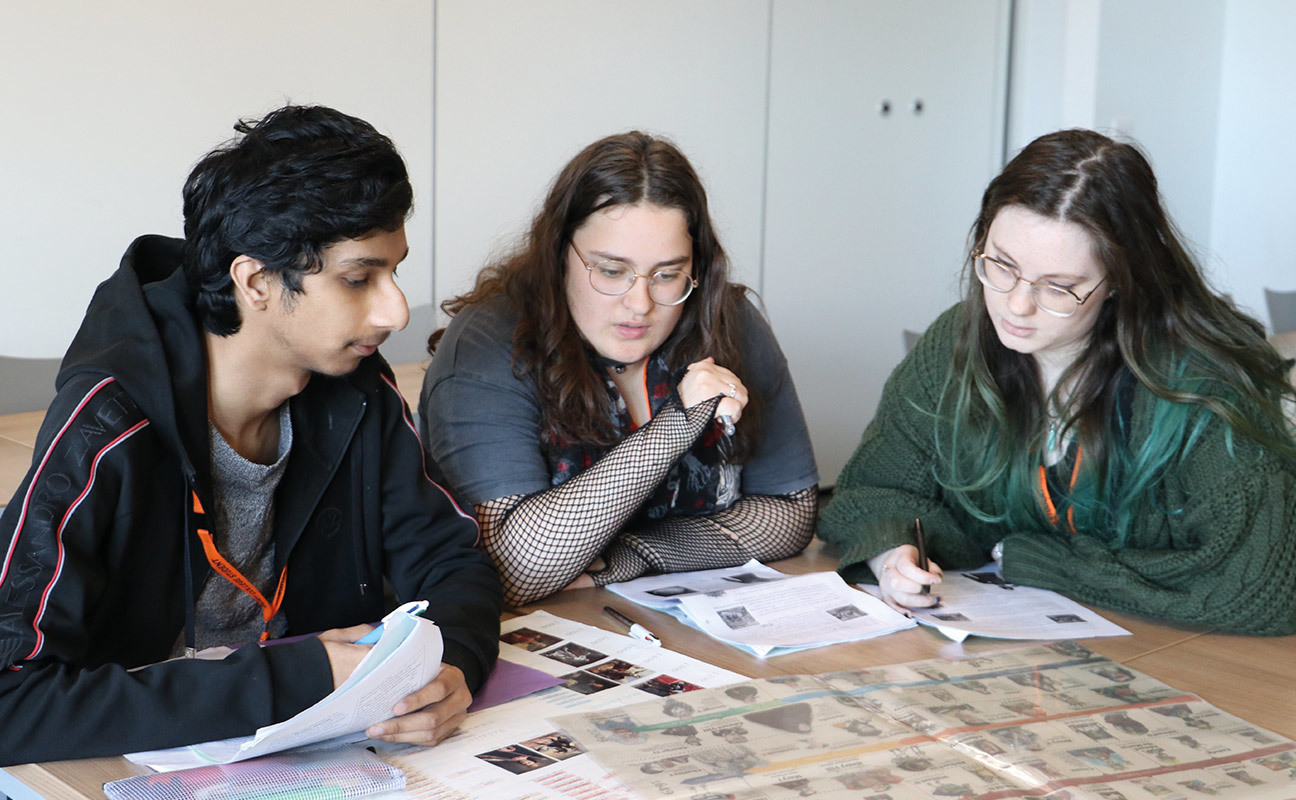 Three students studying a History document
