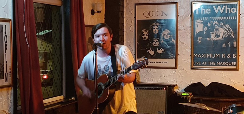 Matthew performing with a Guitar 