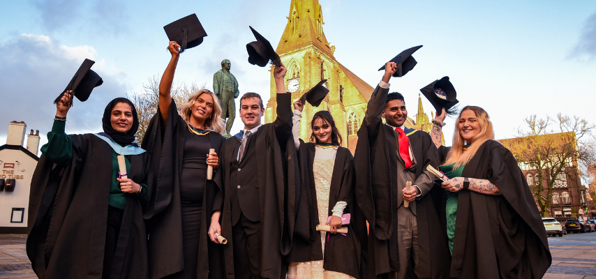 a group of graduates holding their caps in the air