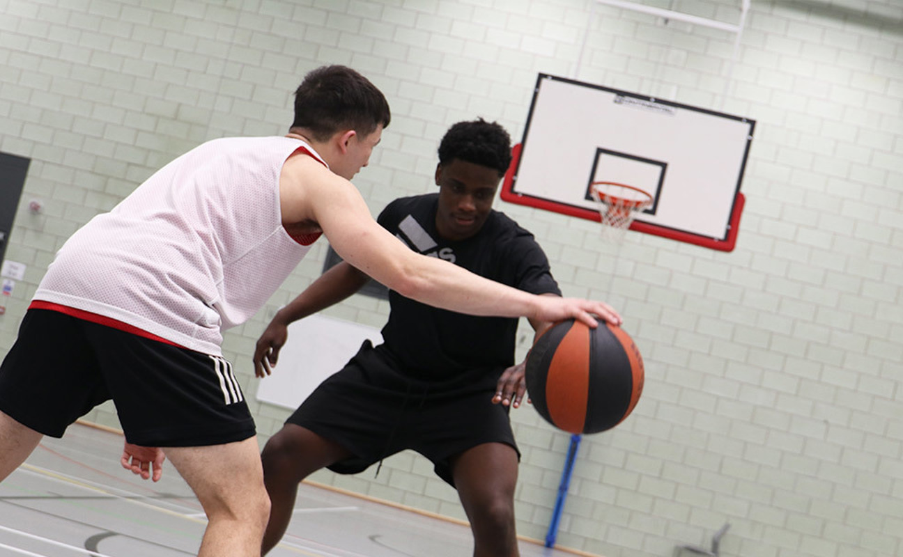 students dribbling with the ball in basketball