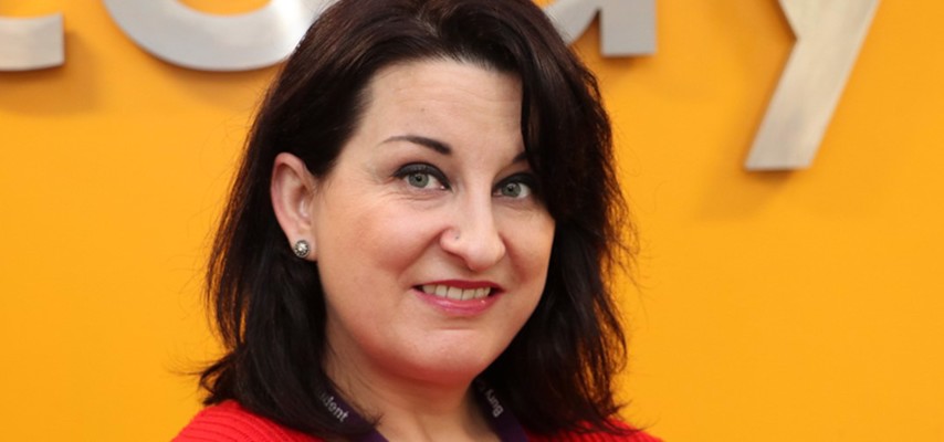 Multilingual Bury College student Sylwia Gorska stood in front of a yellow background