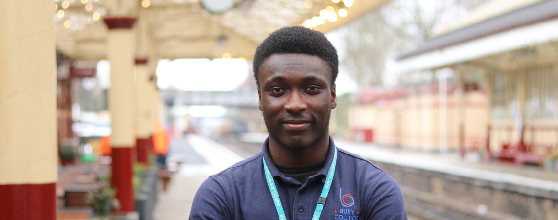 student stood at a train station