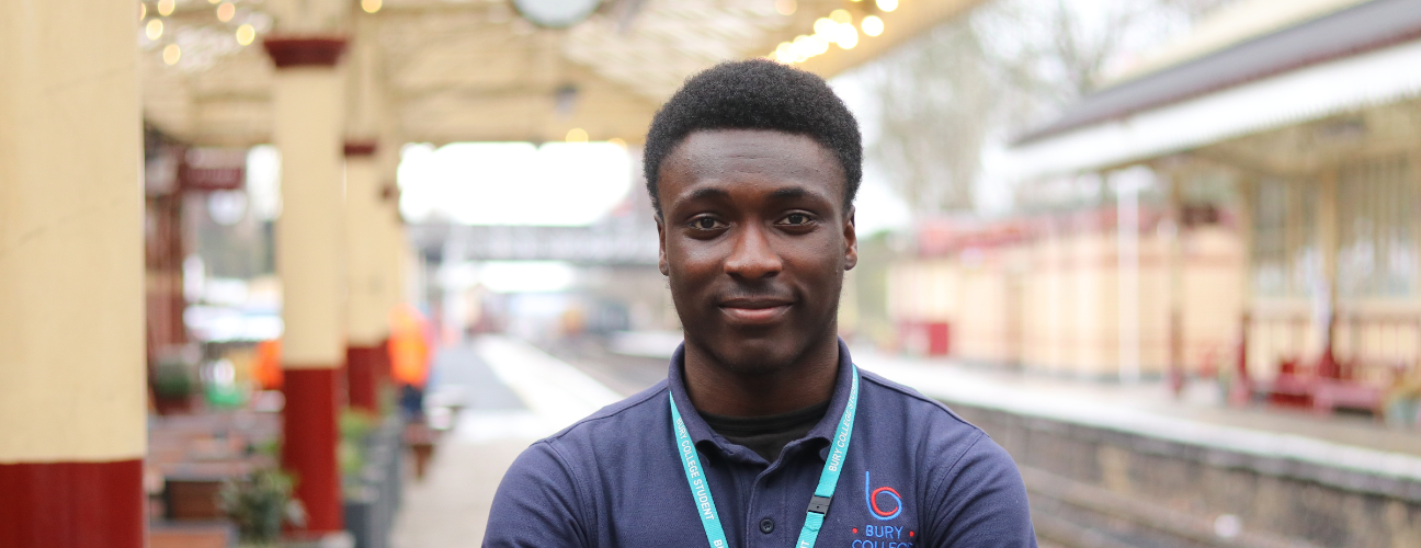 student stood at a train station