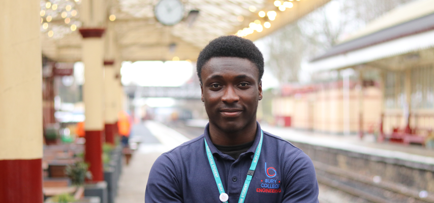 student stood at a train station