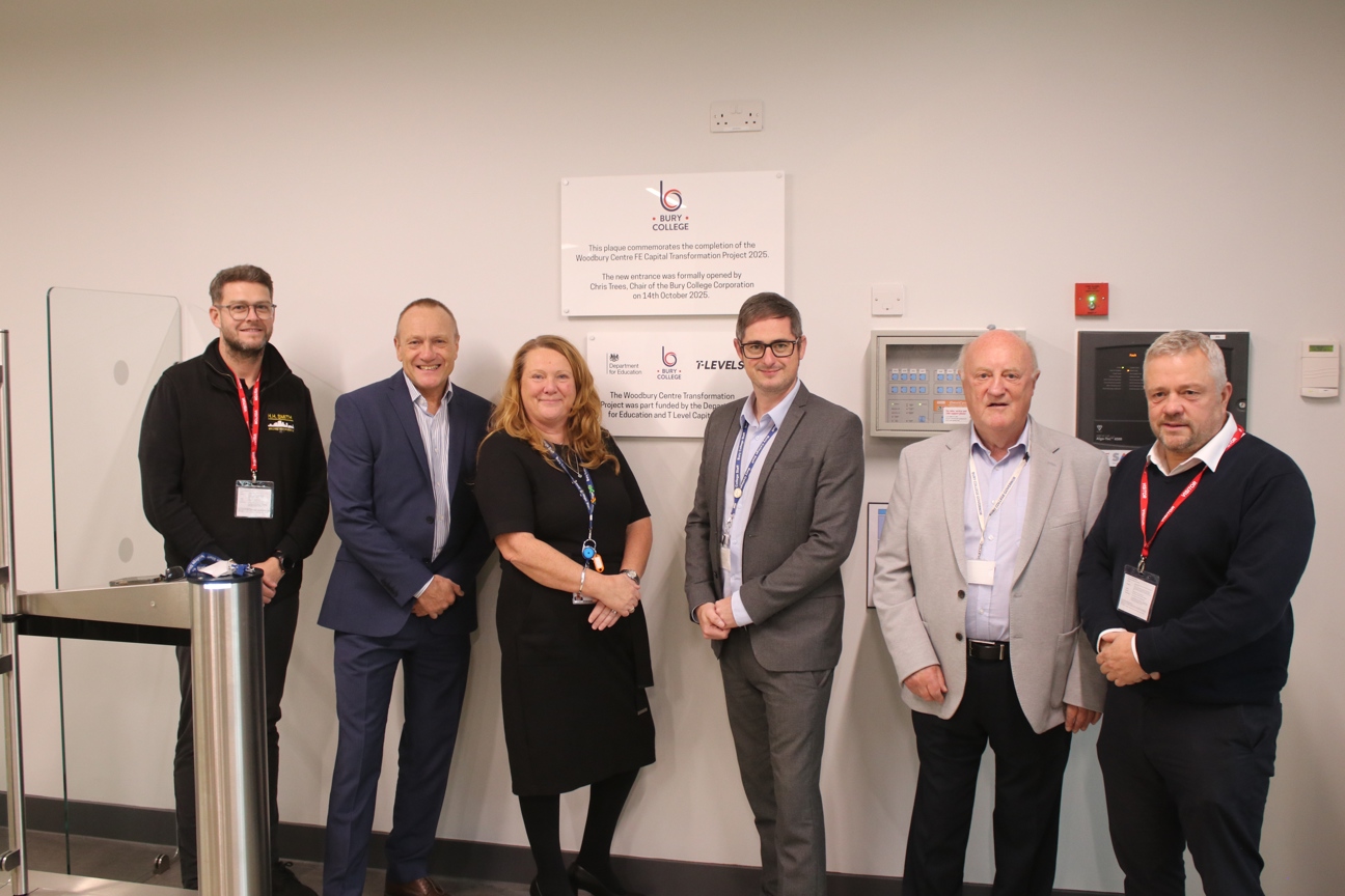 Bury College staff and governors stood in front of plaque