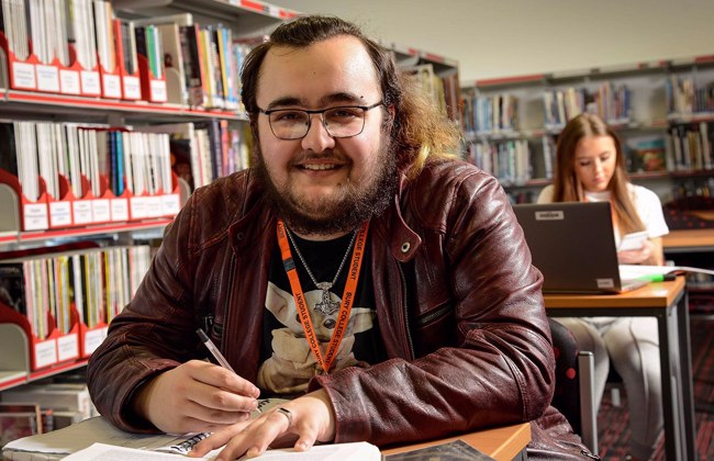 Student smiling to camera in the library