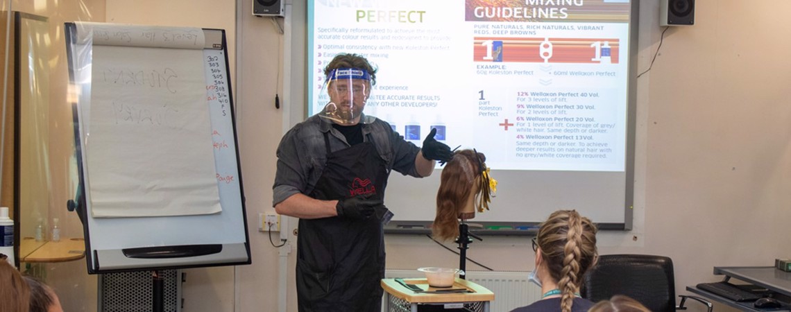 A Wella professional demonstrating techniques to Bury College Hairdressing Level 2 students