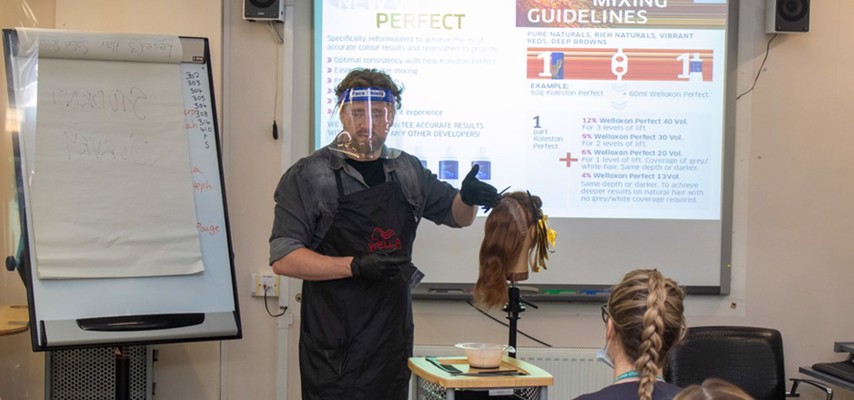 A Wella professional demonstrating techniques to Bury College Hairdressing Level 2 students