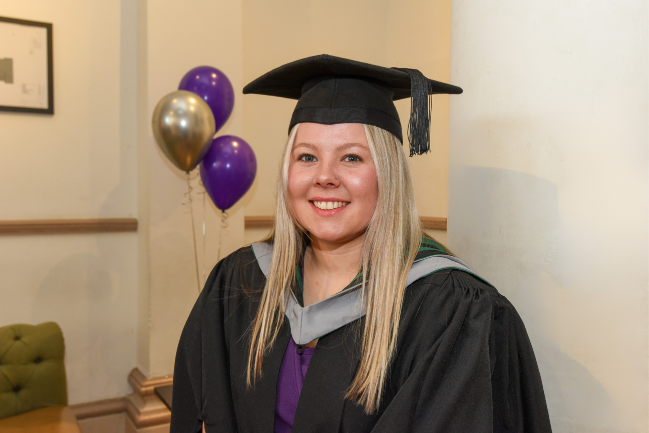 student wearing cap and gown at graduation