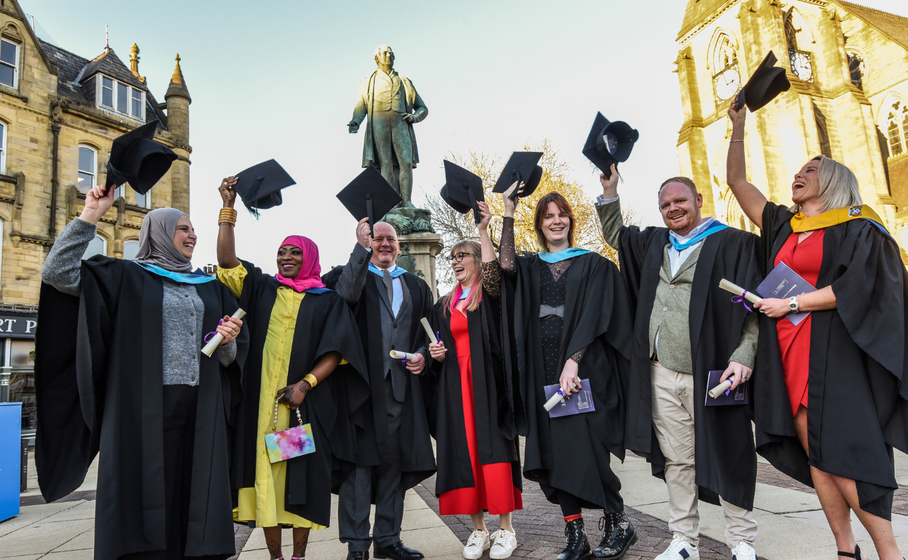 university students on their graduation day holding their caps in the air