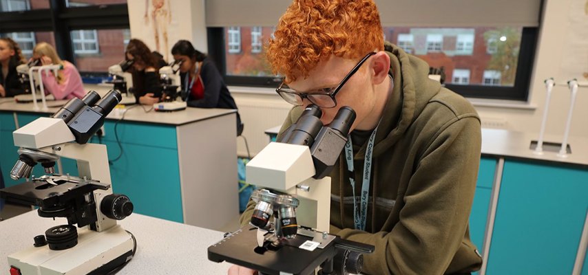 Student looking through microscope